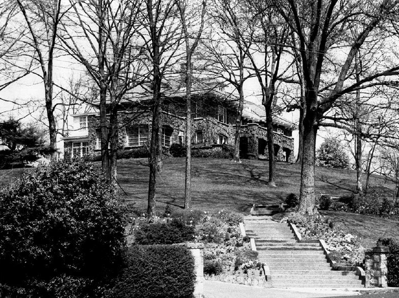 An image of a large home with its first story made of granite.